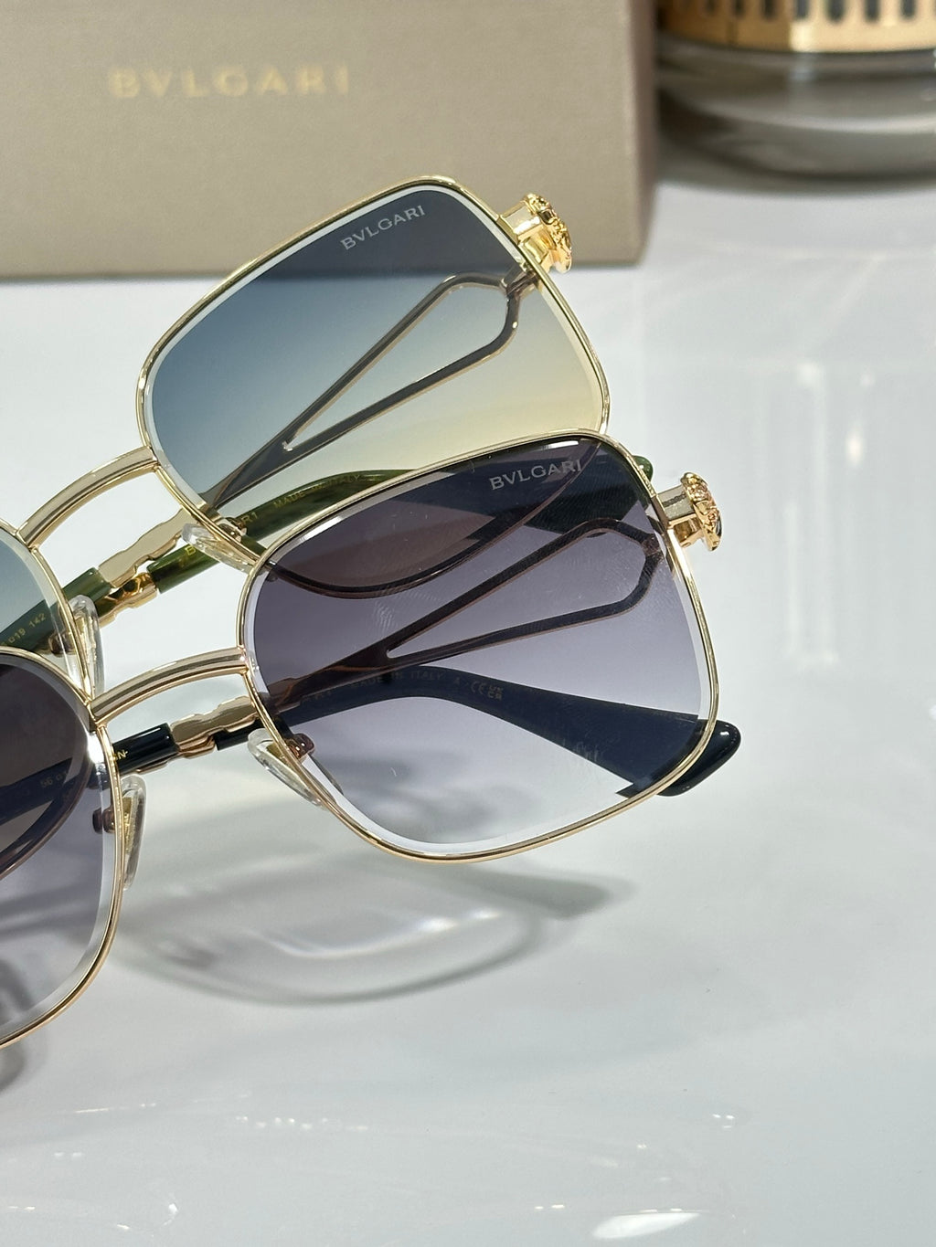 Gold sunglasses close-up with dark lenses and small emblem on frame