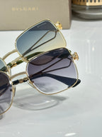 Gold sunglasses close-up with dark lenses and small emblem on frame