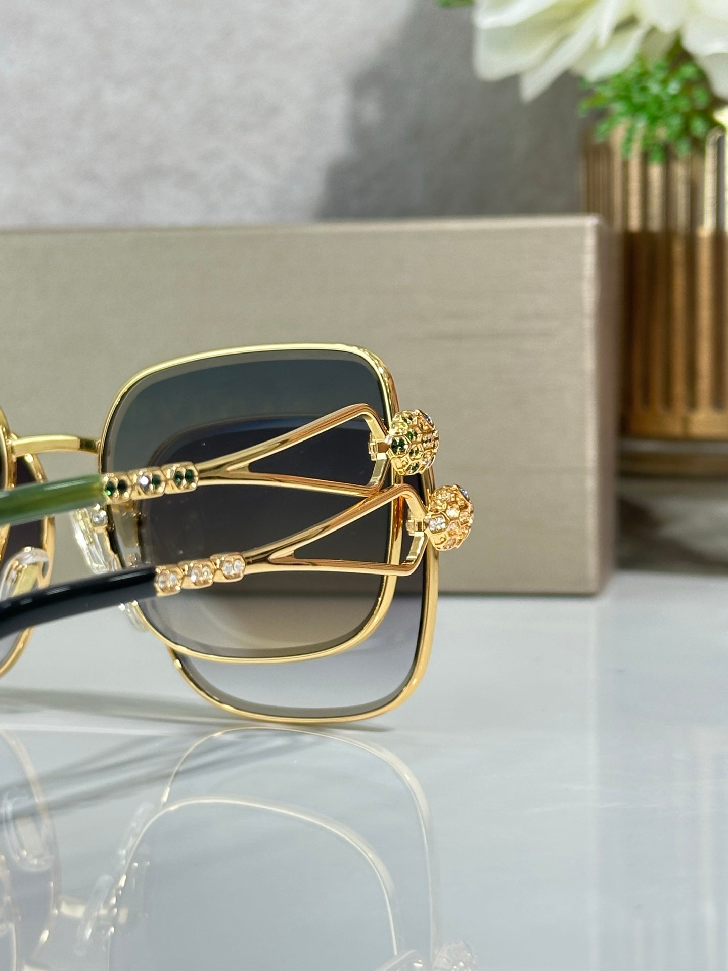 Gold sunglasses close-up with dark blue lenses and hinge detail
