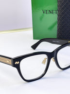 Black eyeglasses side view with gold-pattern temple detail.