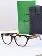 Tortoiseshell eyeglasses with gold temple detail and rectangular clear lenses.