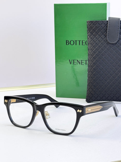 Black eyeglasses with gold temple accents and rectangular clear lenses.