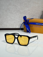 Sunglasses with black square frames and yellow tinted lenses
