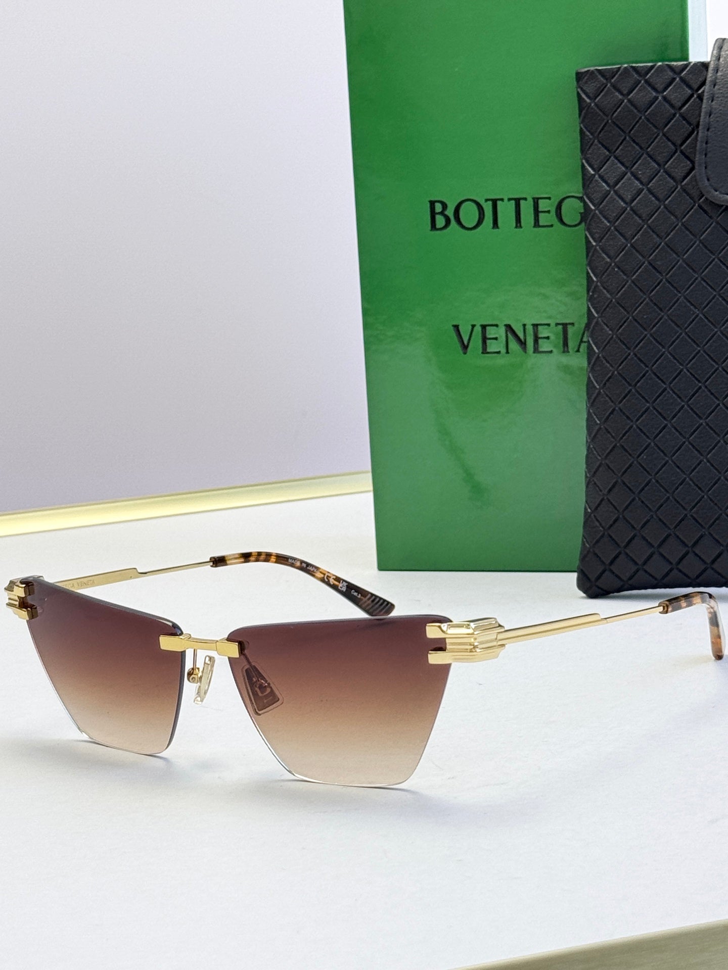 Bottega Veneta sunglasses with gold frame and warm brown gradient lenses