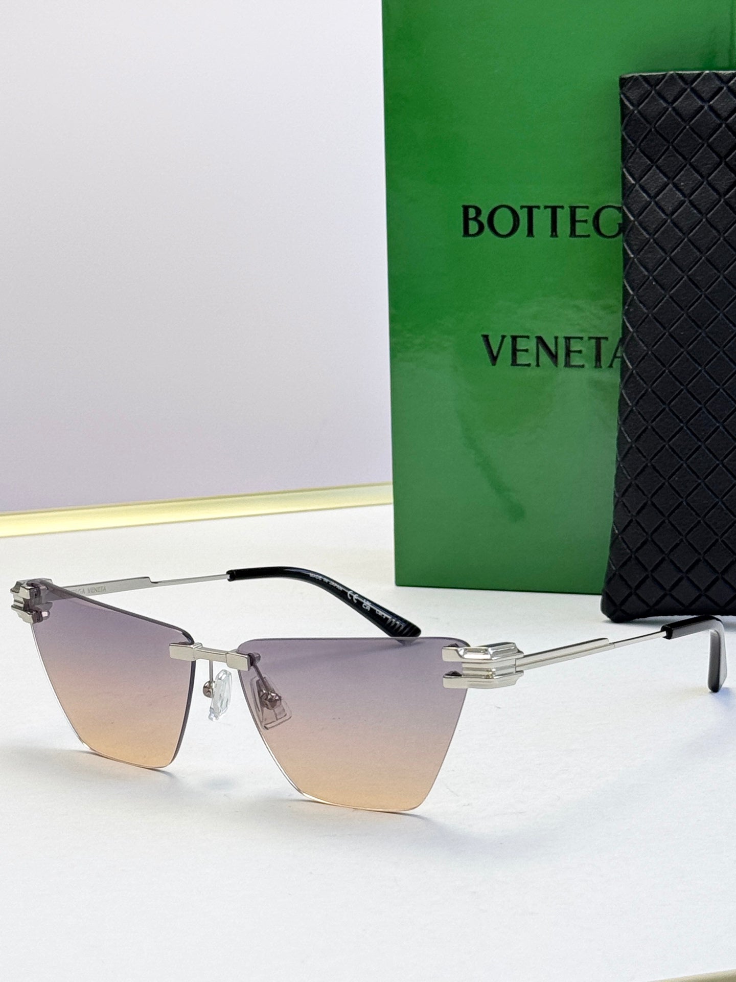 Bottega Veneta sunglasses with dark frame and mauve-toned gradient lenses