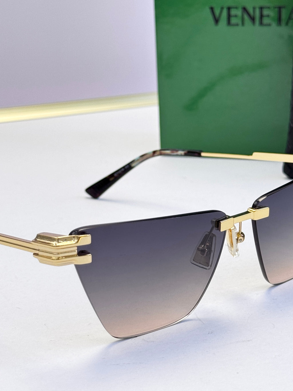 Bottega Veneta sunglasses with gold details and dark gradient lenses