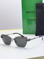 Bottega Veneta sunglasses with dark gray lenses, light gray frame and gold accents