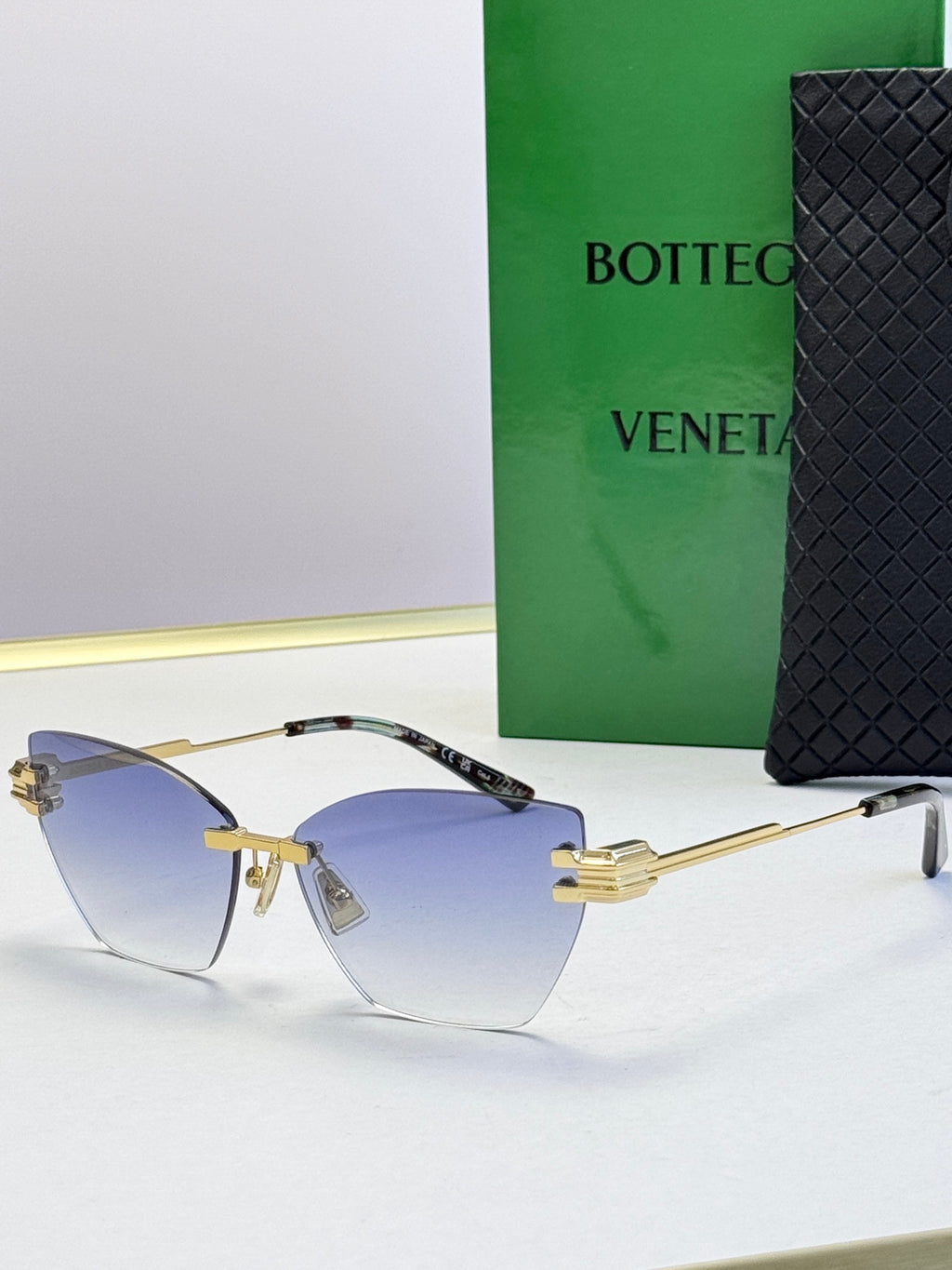 Bottega Veneta sunglasses with gradient blue lenses, gold frame and black-tipped temples