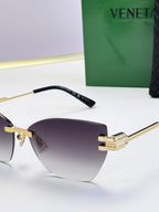 Bottega Veneta sunglasses, close-up of black temple and gold arms with dark tinted lenses