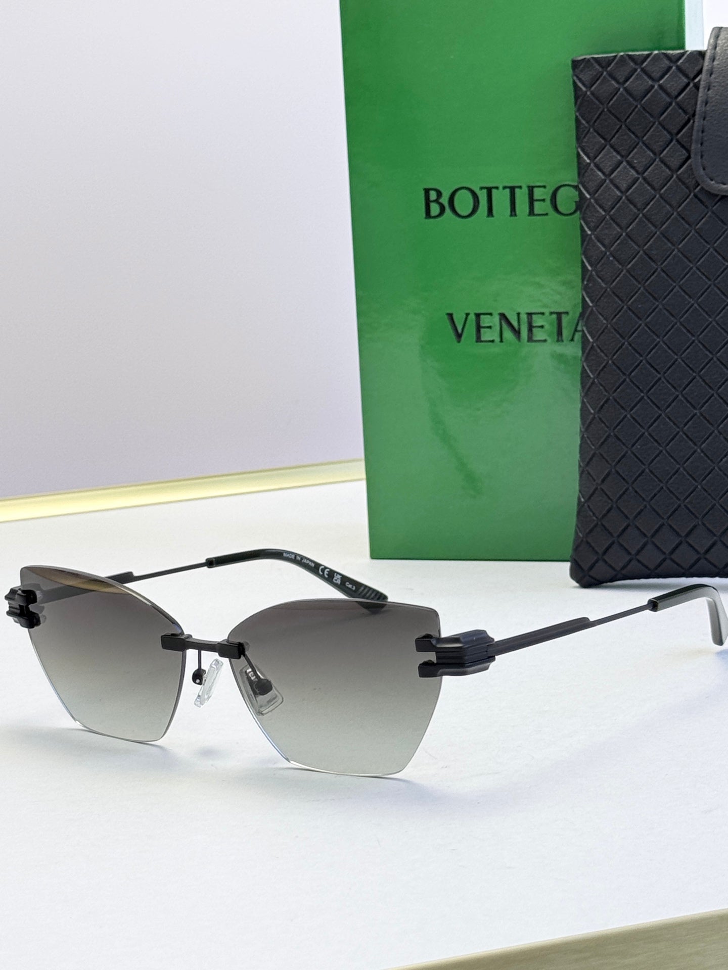 Bottega Veneta sunglasses with dark gray lenses, black frame and gold accents