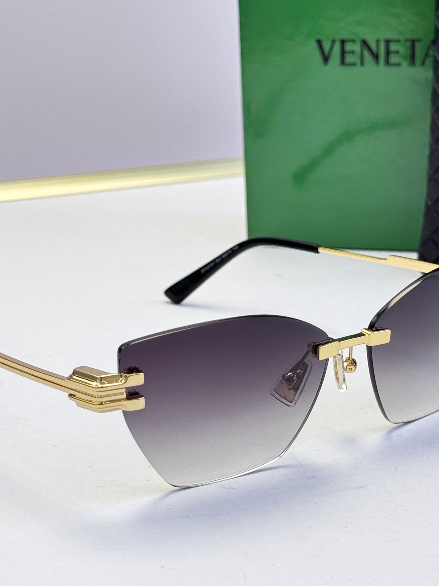 Bottega Veneta sunglasses, gold bridge and arms with dark tinted lenses, black temples