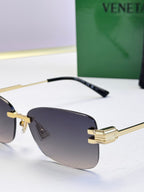 Bottega Veneta sunglasses close-up with gold frame, black temple, dark lenses