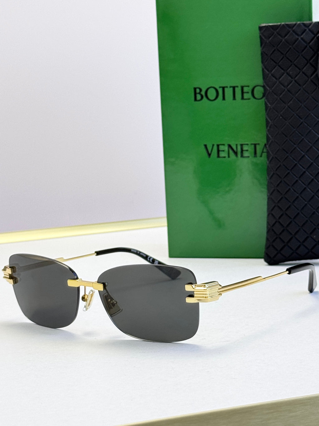 Bottega Veneta sunglasses with gold frame and dark gray gradient lenses
