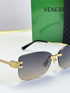 Bottega Veneta sunglasses close-up with gold frame and dark gradient lenses