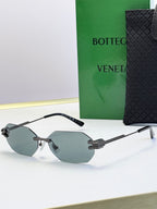 Bottega Veneta sunglasses with black frame and light gray tinted lenses, octagonal shape.