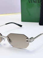 Bottega Veneta sunglasses close-up with silver frame and taupe tinted lenses, octagonal.