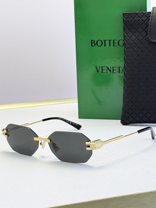 Bottega Veneta sunglasses with gold frame and light gray tinted lenses, octagonal shape.