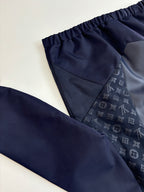 Navy pants close-up with elastic waistband and subtle monogram fabric panel