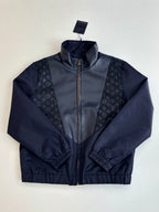 Navy zip-up jacket with stand collar; monogram side panels and ribbed hem