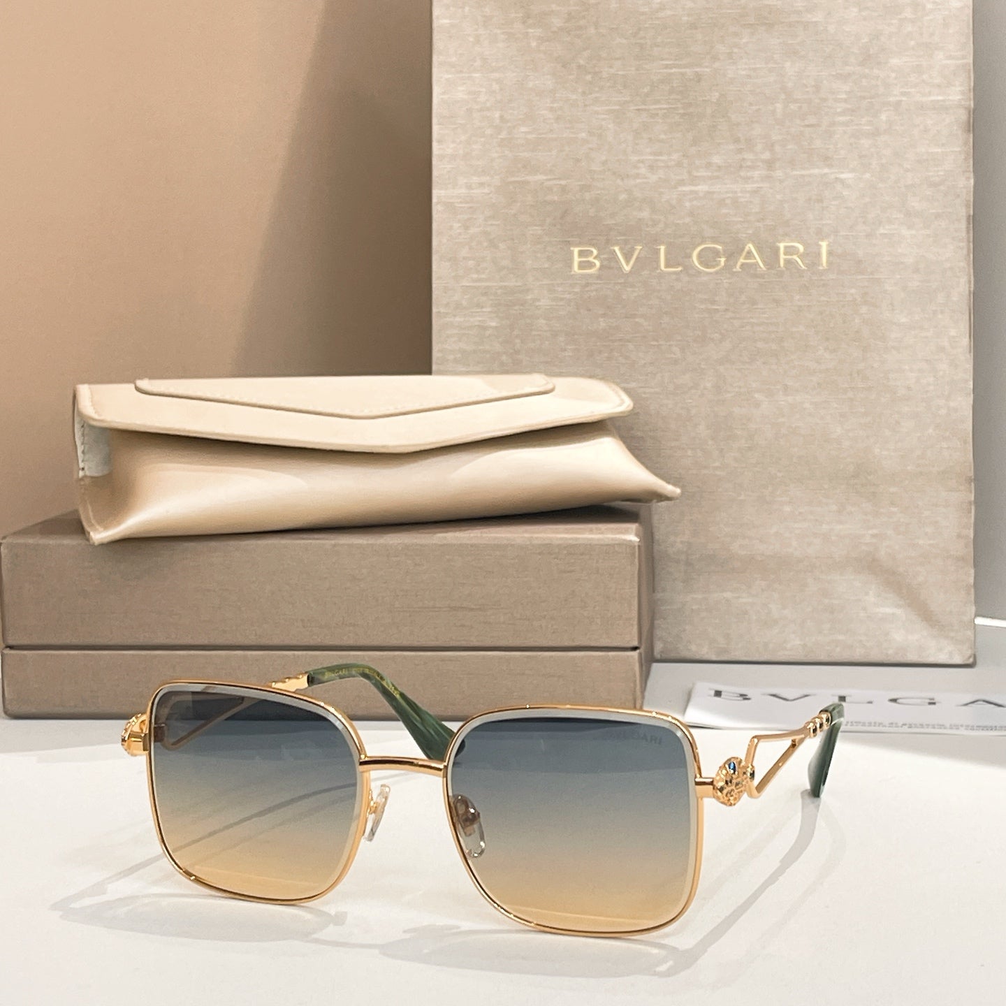 Bvlgari sunglasses with light blue lenses, gold frame and green temples