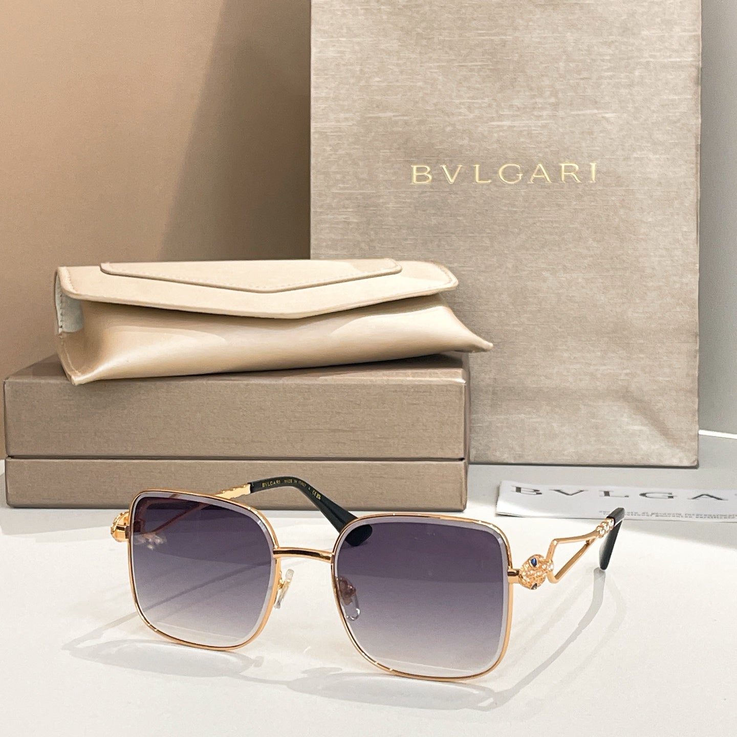 Bvlgari sunglasses with dark blue lenses and gold frame, square style