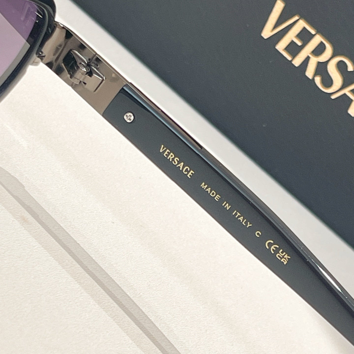 Versace sunglasses arm text, Made in Italy on dark metal temple
