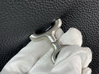 Pebbled leather bag handle with metal clasp and white cloth, close-up