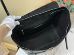 Black leather tote bag with open top and front zipper pocket, front view