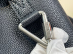 Louis Vuitton bag close-up of metal snap hardware and strap connection