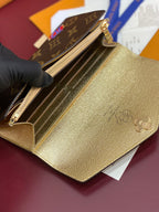 Louis Vuitton small bag open to show gold interior with structured card slots and zipper.