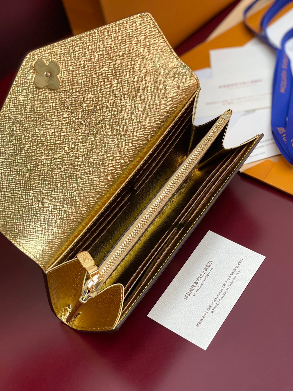 Louis Vuitton small bag open with gold interior, zip track, and card slots.