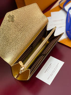 Louis Vuitton small bag open with gold interior, zip track, and card slots.
