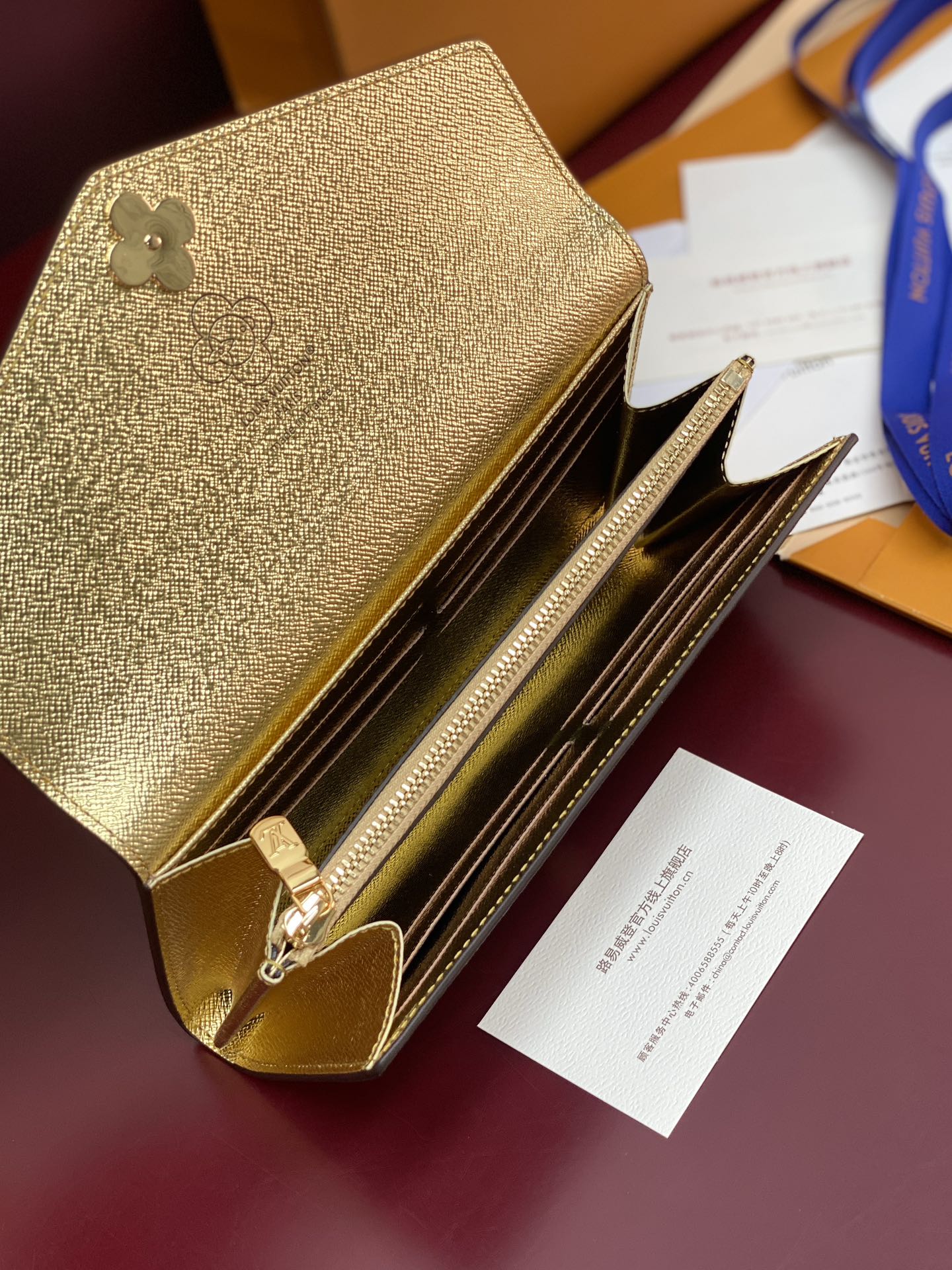 Louis Vuitton small bag open with gold interior, zip track, and card slots.