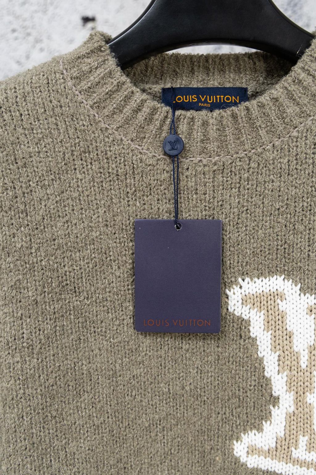 Khaki knit sweater collar with blue Louis Vuitton label and hanging tag
