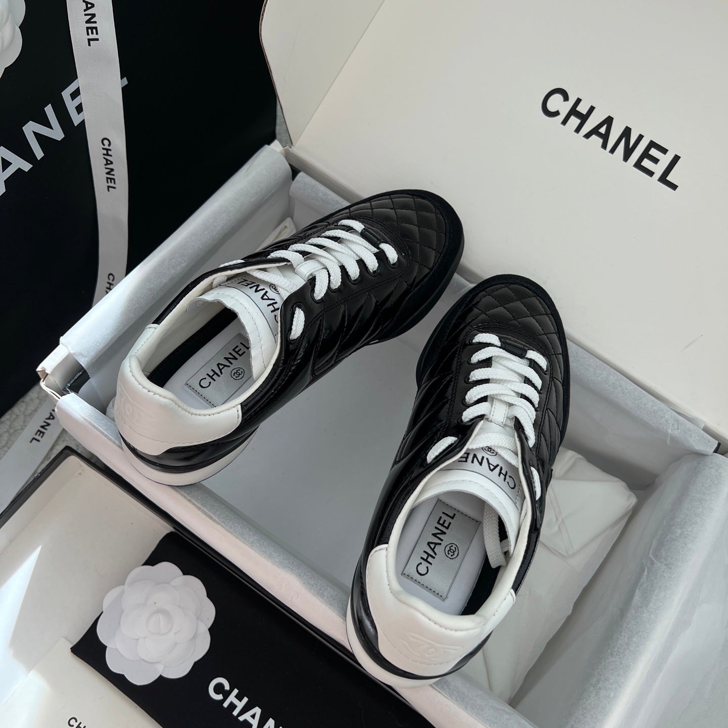 Black quilted unisex sneakers with white laces and white padded collar