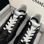 Black and white unisex sneakers with quilted texture and white lace-up front