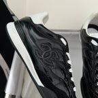 Black quilted unisex sneakers with white lace-up detail and embossed side logo