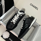 Black quilted unisex sneakers with white laces and Chanel-style logo on side