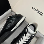 Black quilted unisex sneakers with white laces and side logo patch, low-top profile