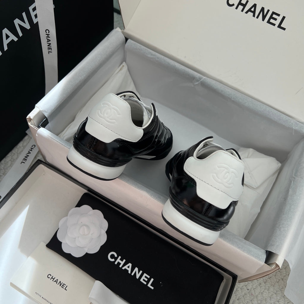 Black unisex sneakers with white laces, black leather uppers, and white rubber midsoles