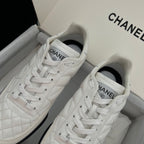 Chanel unisex sneakers, close-up of white lace-up front with Chanel logo on tongue