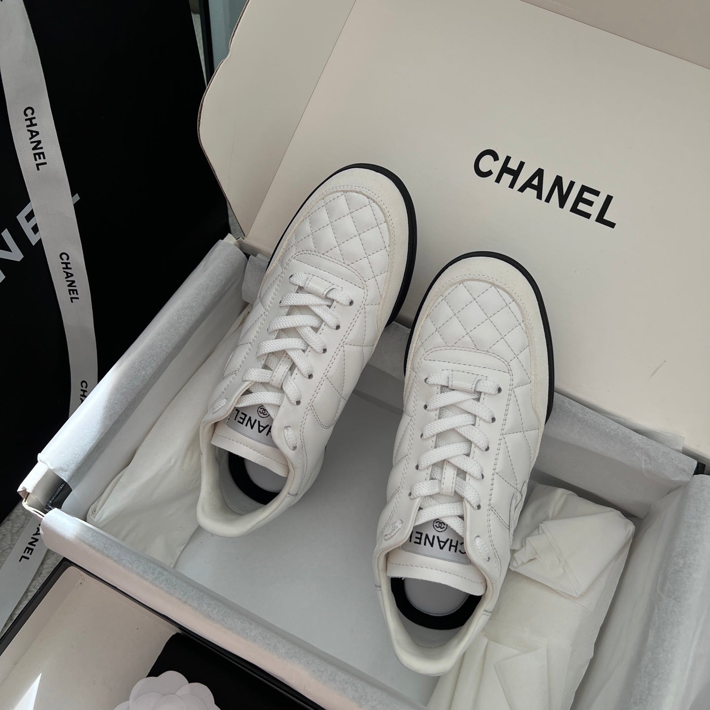 Chanel unisex sneakers, top view of white leather uppers with quilted panels and laces