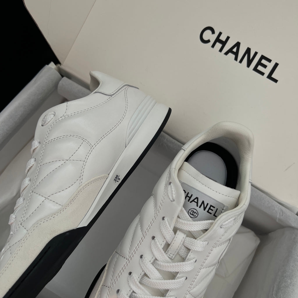 Chanel unisex sneakers, side view of white leather upper with stitched overlays