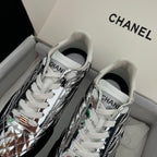 Metallic silver sneakers with white laces and green accent details