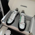 Metallic silver low-top sneakers with white laces and green trim