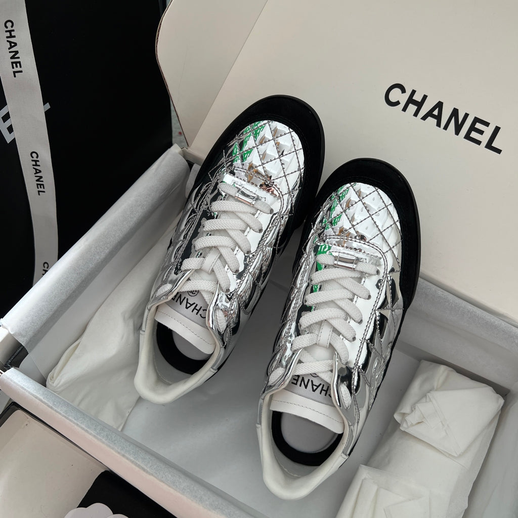 Metallic silver low-top sneakers with white laces and green trim