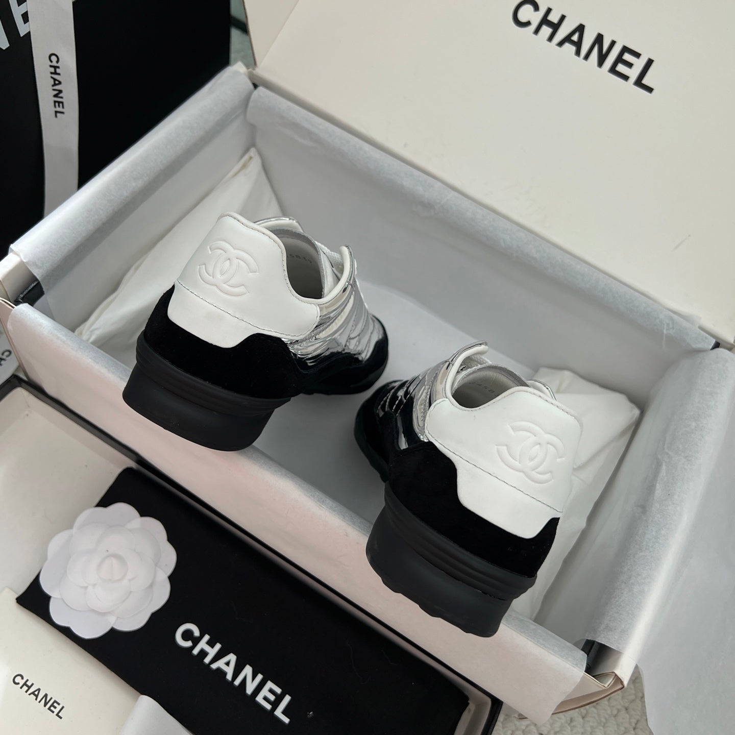 Back view of sneakers with black heel and white logo patch