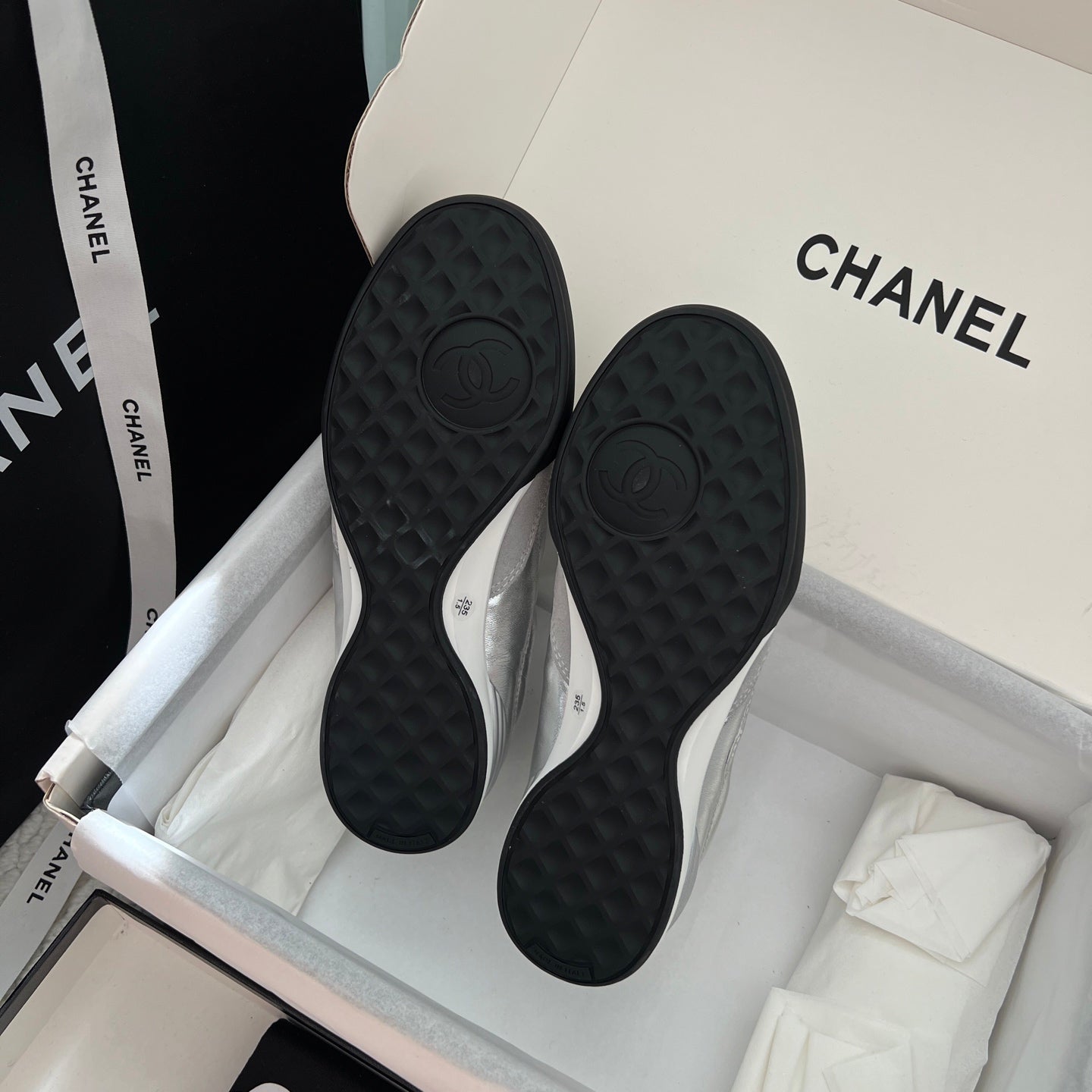 Chanel sneaker outsoles with dark tread pattern and raised CC emblem