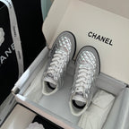 Chanel quilted metallic sneakers with white laces and black trim, front pair