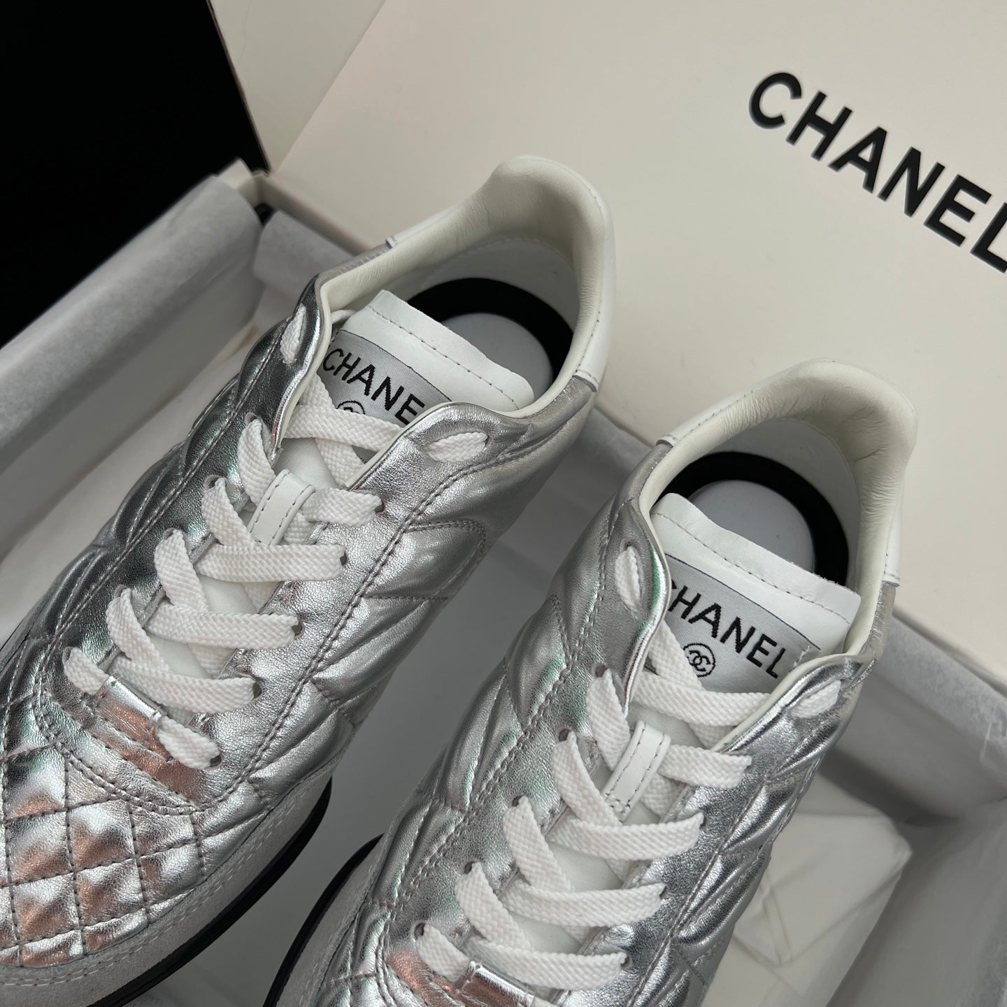 Chanel metallic sneakers, front view: white laces and quilted toe panels